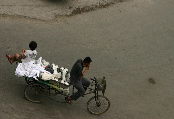 Unusual Transportation of Giant Chromium Bones By Two Girls on Three Wheeled Peddle Bike