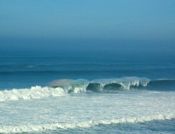 Pacific Ocean rainbow, offshore wind on waves, from a long distance away, Pomponio State Beach, Pescadero, California, USA