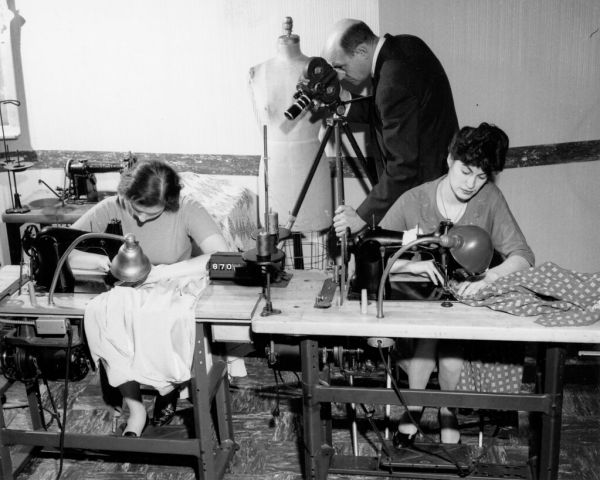 Two women sewing machine operators being filmed for a time-motion study, 1957