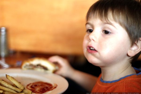 enjoying his own hamburger and french fries in a grown-up restaurant - _MG_0708.embed
